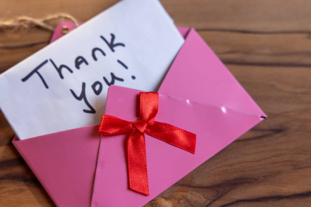A pink envelope with a red ribbon and a note that says \