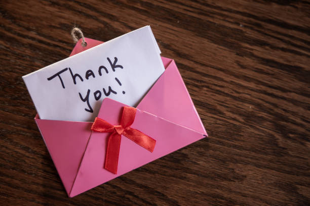 istock A pink envelope with a red ribbon and a note that says 
