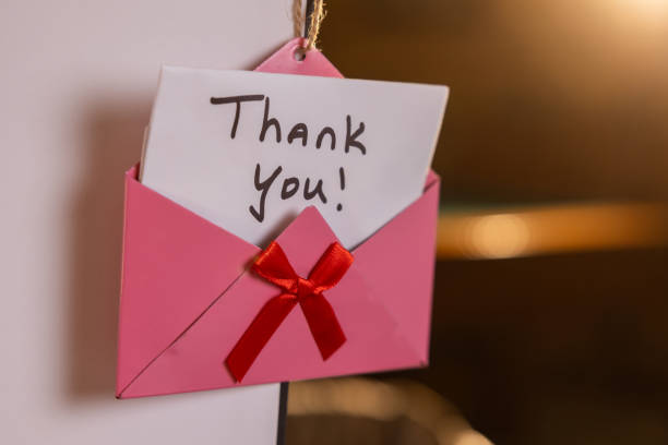 istock A pink envelope with a red ribbon and a note that says 