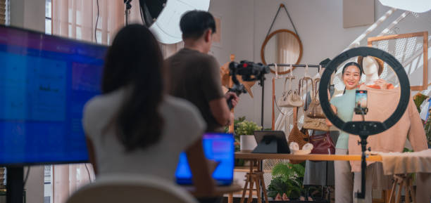 istock selling live stream online marketing behind back office woman programer checking selling statistic from application screen between stylish influencer woman broadcast selling cloth online SME small business e-commerce 2169281748