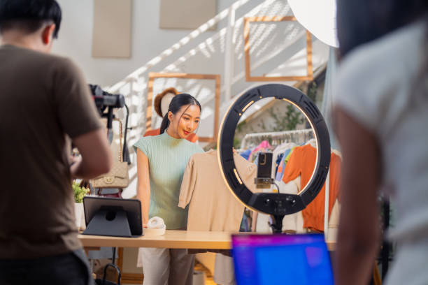 istock selling live stream online marketing behind back office woman programer checking selling statistic from application screen between stylish influencer woman broadcast selling cloth online SME small business e-commerce 2169281910