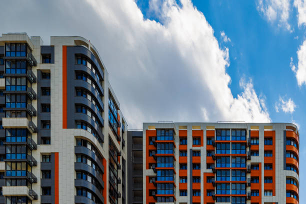 istock freshly built high rise apartment building on blue sky background with white clouds 2169283467
