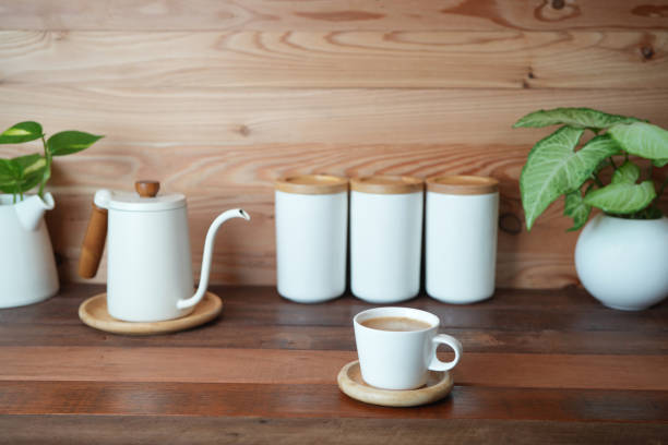 istock Coffee in a white cup and kettle on wooden counter 2169283652