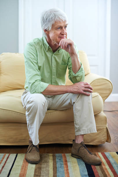 istock Senior man, thinking and memory on sofa with smile, reflection or choice with perspective in retirement. Elderly person, happy or remember for nostalgia, wonder or insight for decision in living room 2169284767
