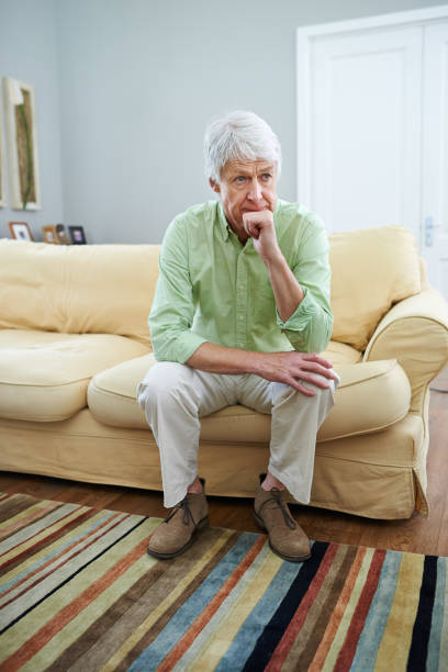 istock Senior man, reflection and couch in home with ideas, memory and thinking with perspective in retirement. Elderly person, sad and remember with nostalgia, wonder or insight for decision in living room 2169284771