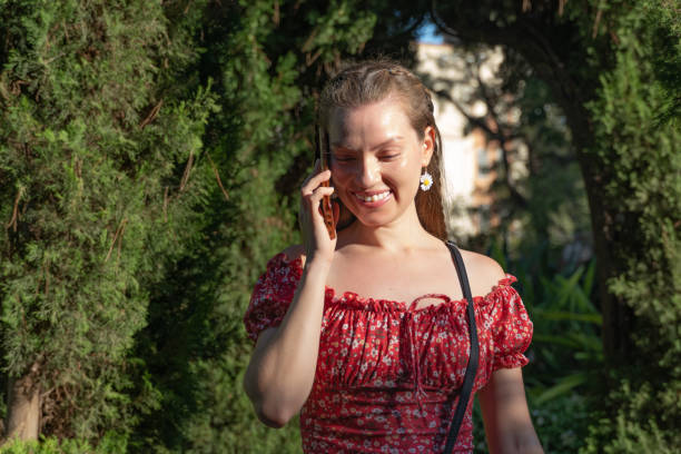 istock Young redhead woman smiling while talking on her smartphone in a park. 2169286229