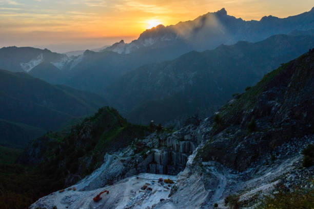 Carrara marble quarries at sunset, destruction of Apuan Alps landscape and ecosystem