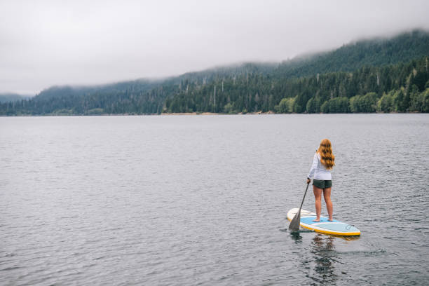 istock Young woman SUP boards across lake 2169296681
