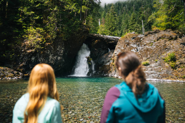 Young women explore waterfall and pond