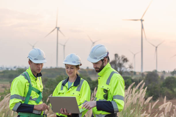 istock Team of engineers working and using a computer laptop on site in wind turbine farm, Wind turbines generate clean energy source, Eco technology for electric 2169298221