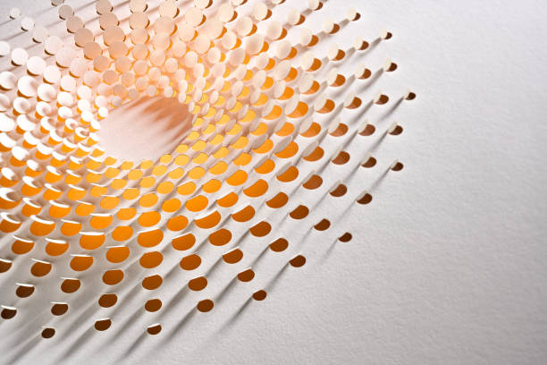 Native image size: 7952 x 5304. A mesmerizing close-up of a meticulously crafted paper art design featuring a sun-like pattern, with precision-cut holes forming concentric circles. The interplay of light and shadows emphasizes the intricate details, giving the impression of glowing rays emanating from the center. The warm tones of orange and yellow gradients enhance the sun-like effect, creating a captivating piece of abstract art that highlights the beauty of minimalism and craftsmanship.