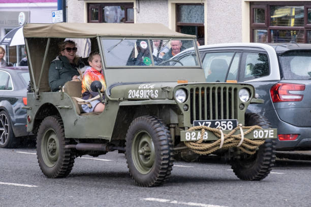 Ballycastle, UK - August 24th, 2024:  green camouflage US Army jeep, vintage, ww2 era, 82AB 307E, taking part in tractor run through town centre.