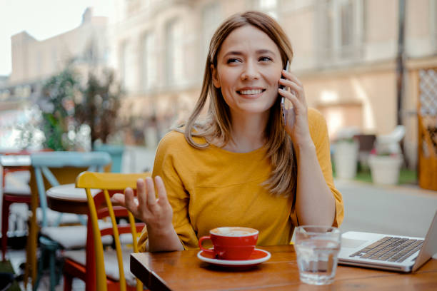 istock Woman Calling With Cell Telephone While Sitting Alone in Coffee Shop 2169310135