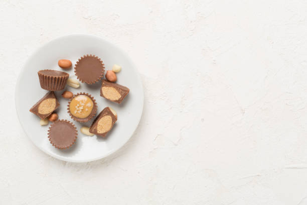 istock Delicious peanut butter cups with nuts on concrete background, top view 2169324579