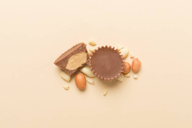 istock Tasty chocolate peanut butter cups on color background, top view 2169324583