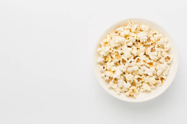 istock Tasty popcorn in bowl on color background, top view 2169324584