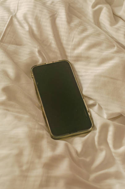 istock Smartphone lies on white bed linen set 2169326967