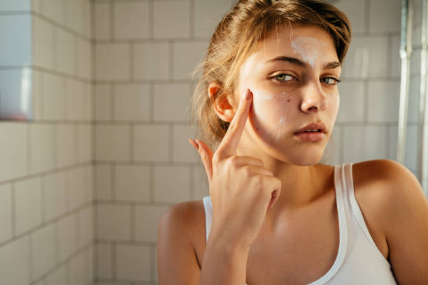 istock Young woman applying moisturiser cream 2169336662