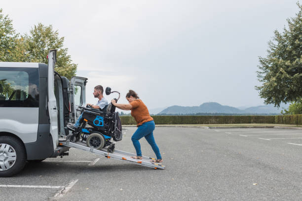 istock Man with a disability getting into an accessible vehicle with help 2169337014