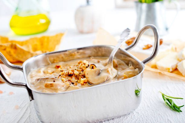 Mushroom sauce in metal bowl on white table
