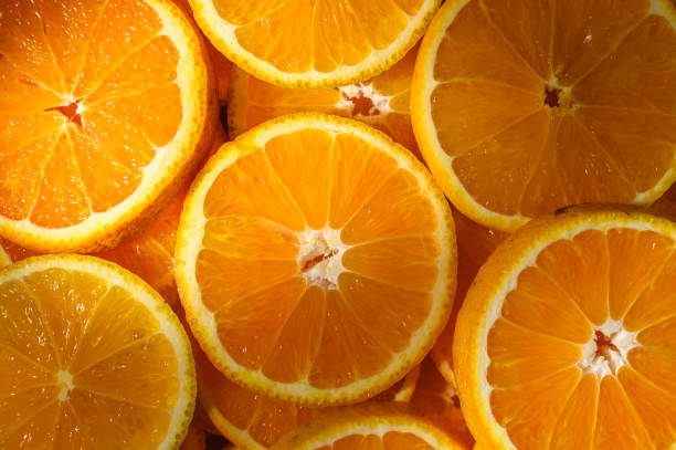 istock Colorful slices of fresh oranges as background with sun rays 2169351949