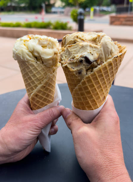 Two Ice Cream Cones Held Up On Warm Day In Springdale