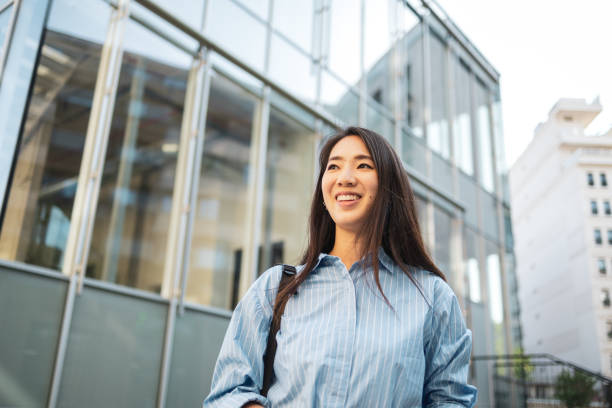 istock Asian woman smiling while commuting in an urban environment 2169359611