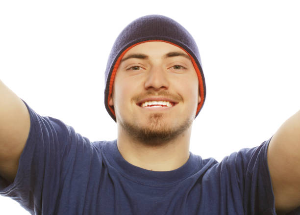 Serious young man wearing a toque hat looking at the camera at a coffee shop
