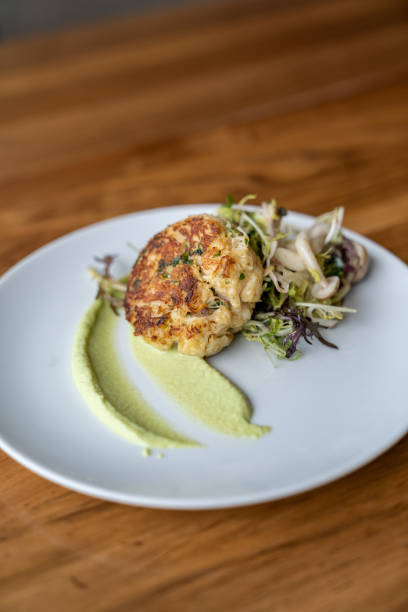 Crab cake appetizer with garnish on a white plate at a fancy restaurant