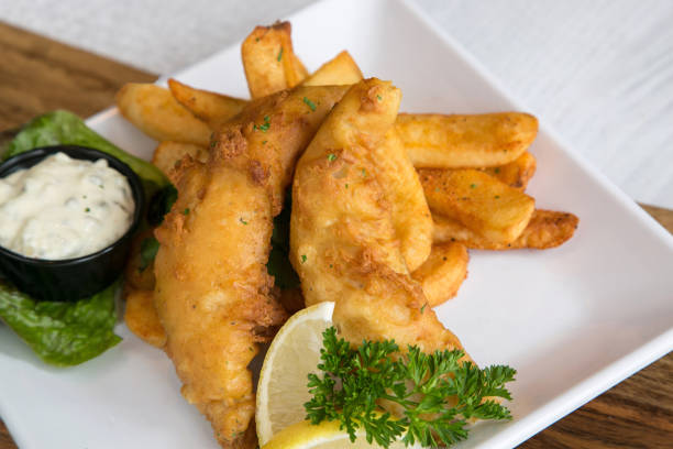 istock Fish and chips on white plate with tartar sauce and lemon wedge 2169362615