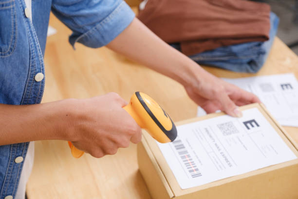 istock Asian man business owner scanning barcode on delivery parcel. 2169363058