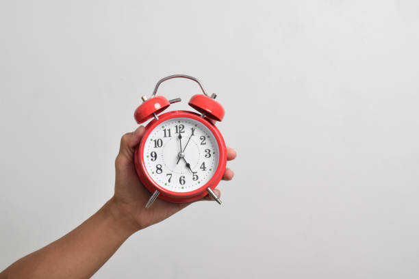 istock Vintage red alarm clock in hand. Round red alarm clock 2169370267