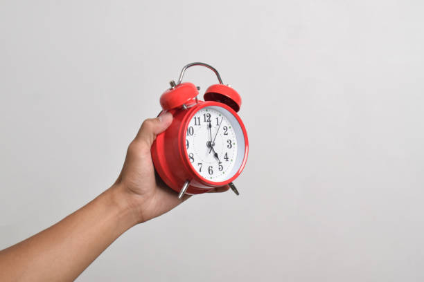 istock Vintage red alarm clock in hand. Round red alarm clock 2169370286