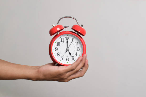 istock Vintage red alarm clock in hand. Round red alarm clock 2169370337