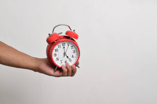 istock Vintage red alarm clock in hand. Round red alarm clock 2169370347