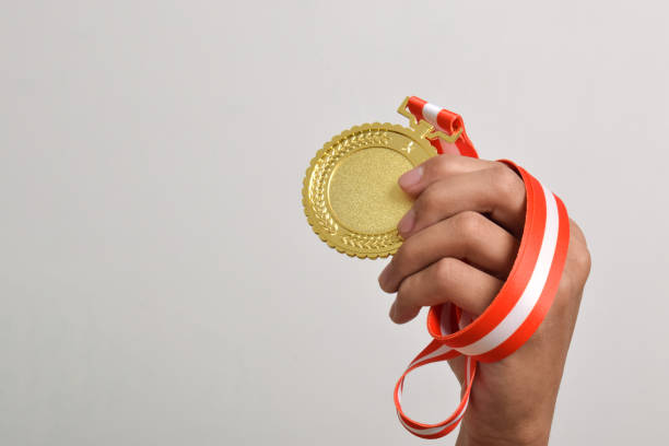 istock Hand holding gold medal. The winner and successful concept 2169373313