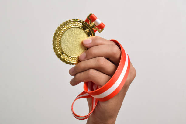 istock Hand holding gold medal. The winner and successful concept 2169373327