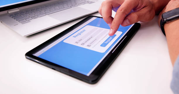 istock Businessman's Hand Filing Online Registration Form 2169373923