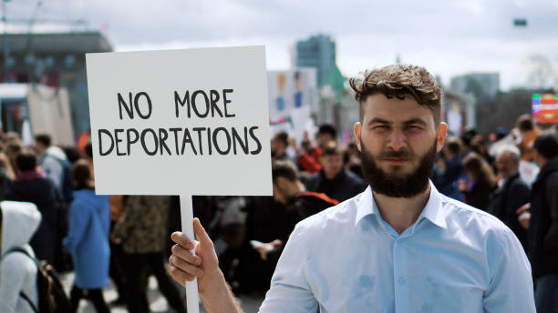 istock Man hold no more deportation banner. Immigration protest. Immigrants problem. 2169382009