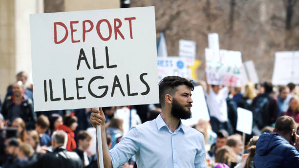 istock Man hold deport illegals banner. Immigration crisis protest. Immigrants problem. 2169382024