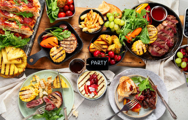 istock Table with grilled food. Pizza, corn, tomatoes, peppers, cooked meat. BBQ time 2169383264