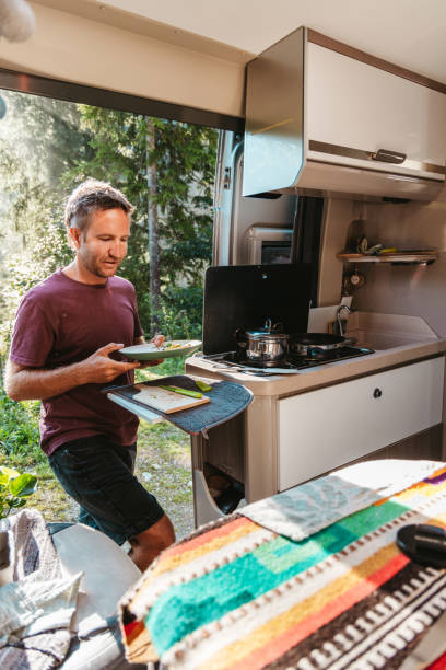 istock Man Serving Food from Camper Van Kitchen 2169385801