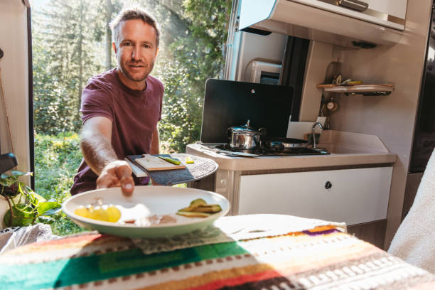 istock Man Serving a Fresh Meal from Camper Van Kitchen 2169385818
