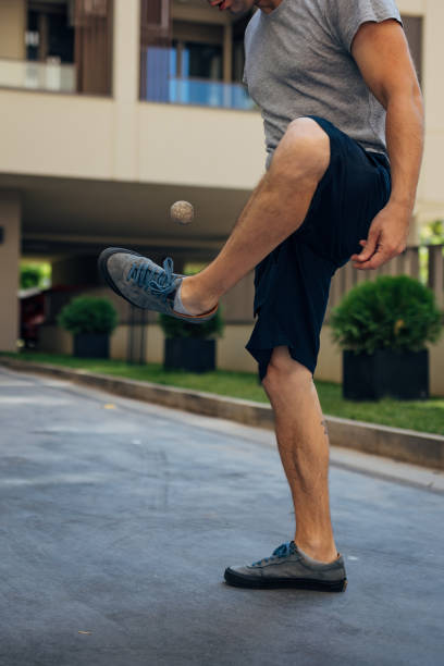 istock An unrecognizable man balances and kicks a footbag. He performs various tricks and plays a game called hacky sack during the day 2169387238