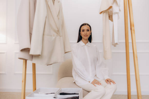 A young woman hangs clothes on a hanger