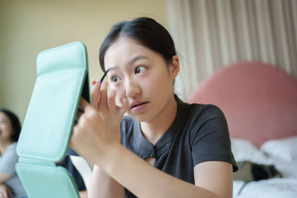 istock Asian woman drawing eyebrows at home 2169390530