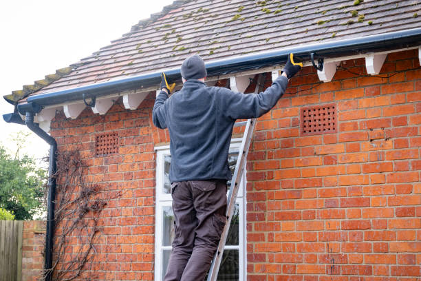istock Man on a ladder fixing rain gutter on a UK house 2169392535