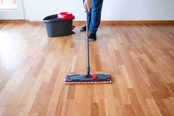 istock Unrecognizable man using a cleaning mop on an apartment wooden tile floor or Parquette flooring. Wide angle shot, selective focus, natural window light 2169394568