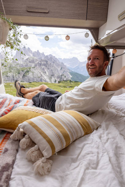 istock Man Taking a Selfie in Bed with Panoramic Mountain View 2169395900