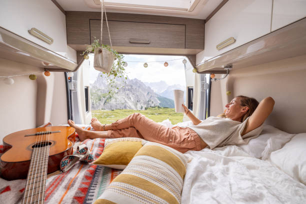 istock Relaxing in Camper Van with Book and Guitar, Overlooking Mountains 2169395947